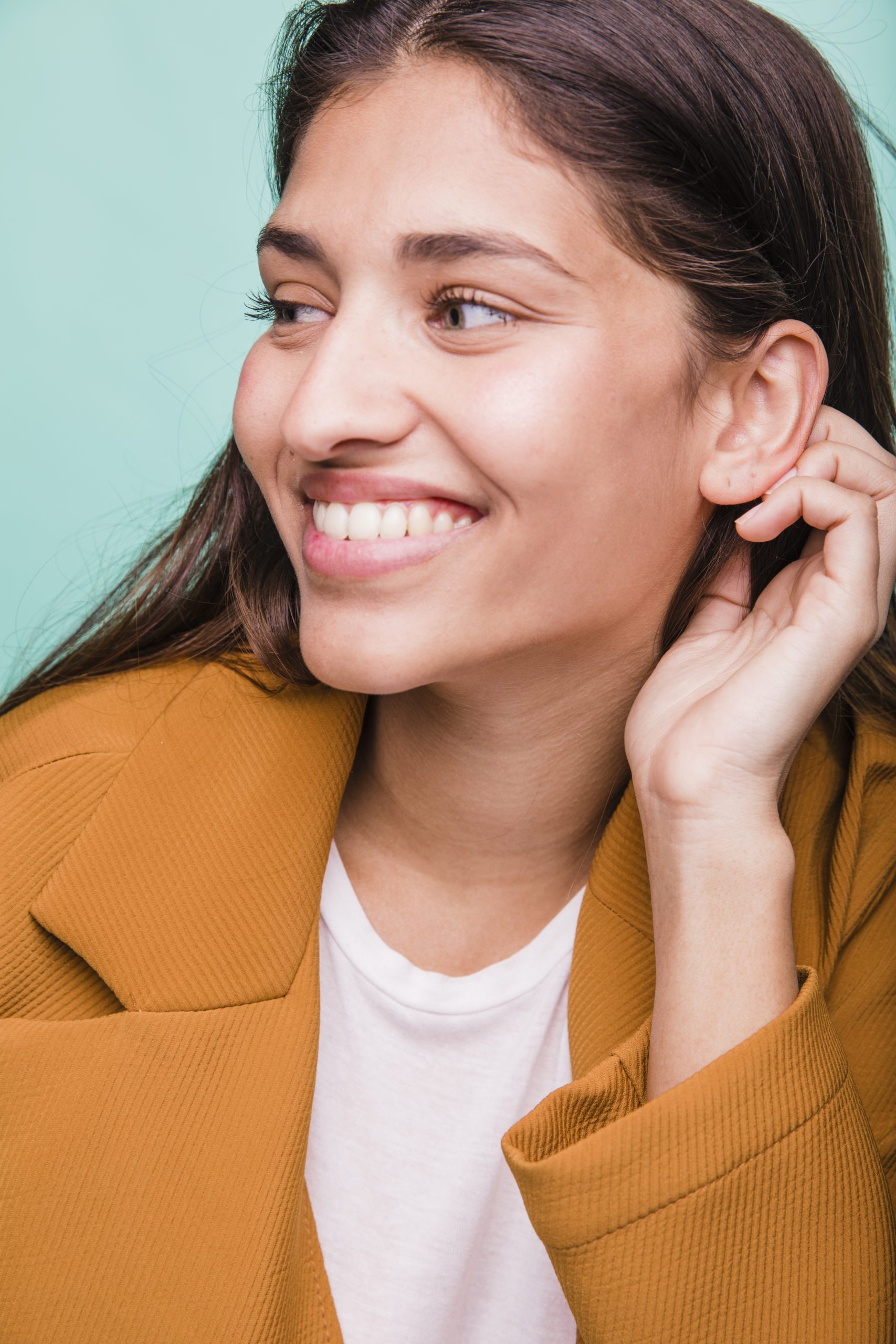 chica morena sonriente posando con abrigo scaled